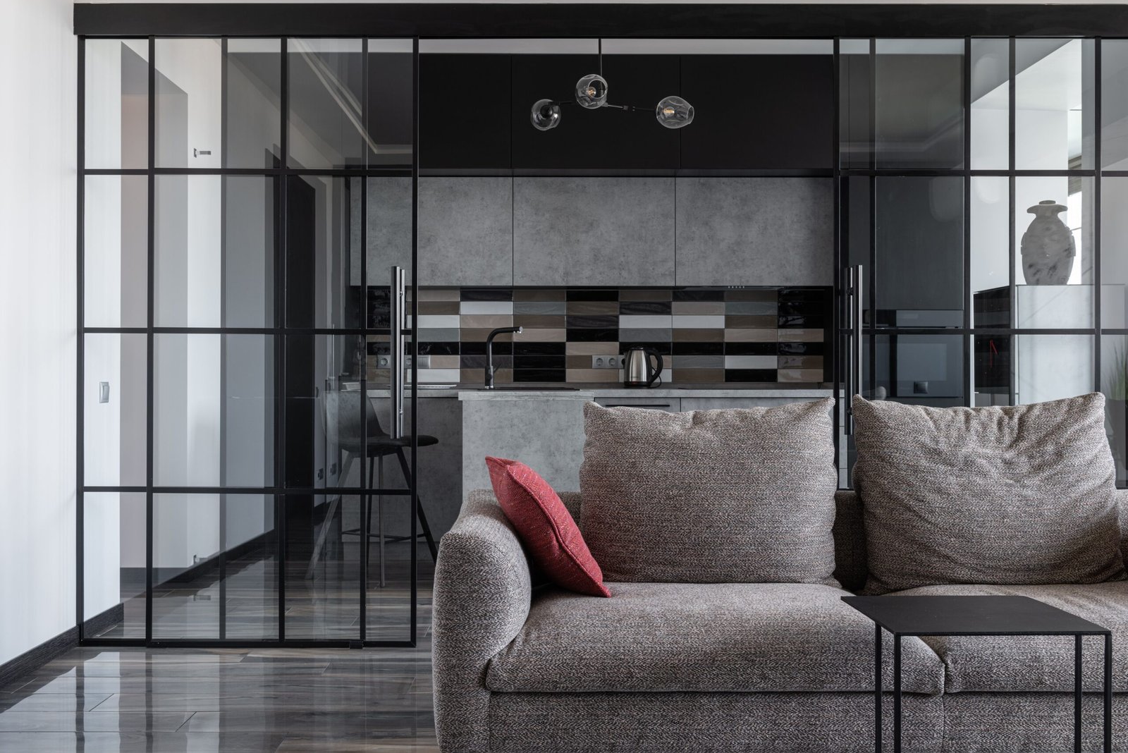 Contemporary living room with cozy sofa and open kitchen view.